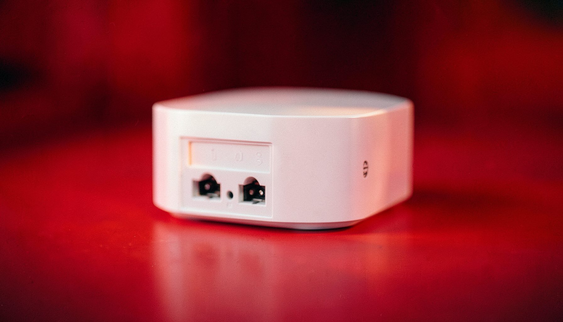 Télérupteur modulaire blanc compact avec bornes de raccordement visibles, éclairage latéral doux